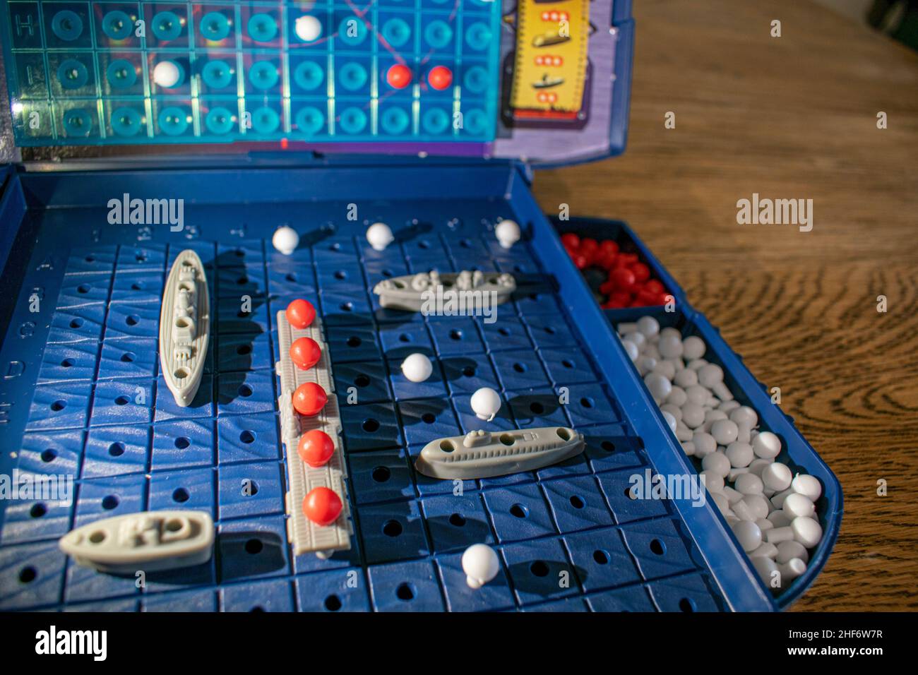 Plastikspielzeug-Kriegsschiffe und U-Boote werden auf dem Spielbrett platziert, das den Ozean darstellt. Der andere Spieler versucht, Ihre Boote im Spiel Batt zu versenken Stockfoto
