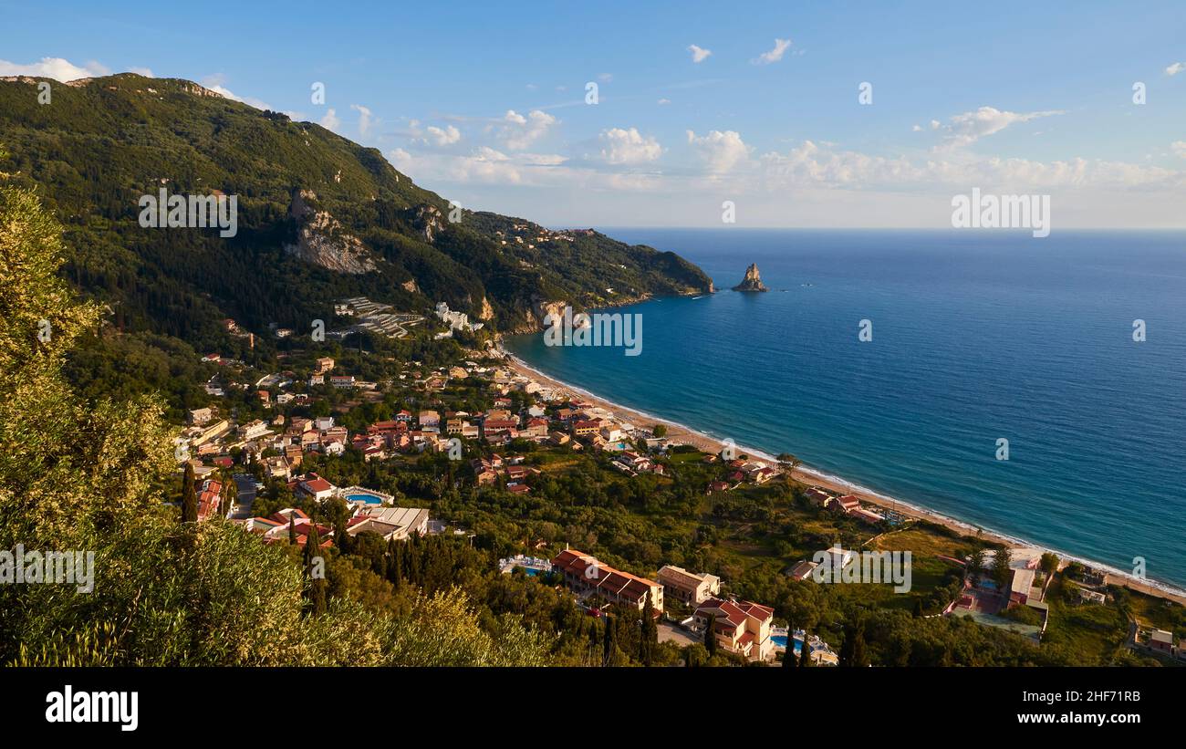 Griechenland, griechische Inseln, Ionische Inseln, Korfu, Westküste, Agios Gordios, Blick von oben auf die Bucht, Häuser, Hotels, im Hintergrund auf dem linken grünen Küstenhügel, daneben der vorgelagerte Felsen Ortholithos Stockfoto