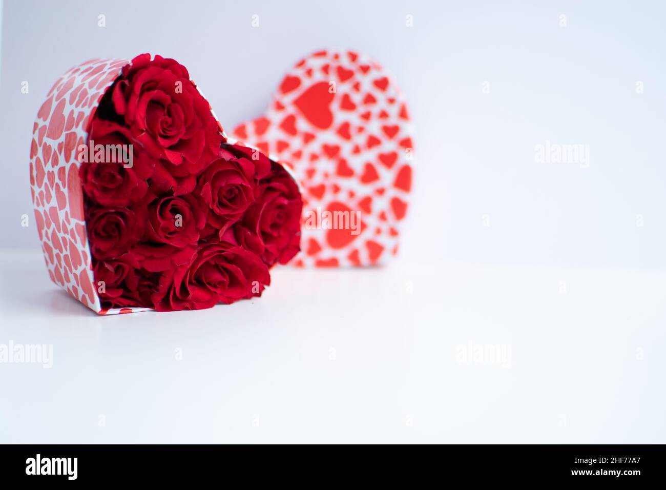 Rotes Rosenstrauß in einer herzförmigen Schachtel Stockfoto