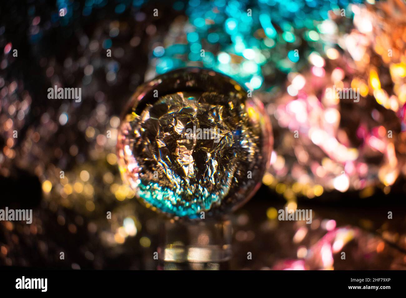 Schneekugel Fotografie Kristallkugel transparente Linse auf einem unscharfen Hintergrund, sehr künstlerisch, futuristisch, bunt, lebendig. Cooler Hintergrund und Backd Stockfoto