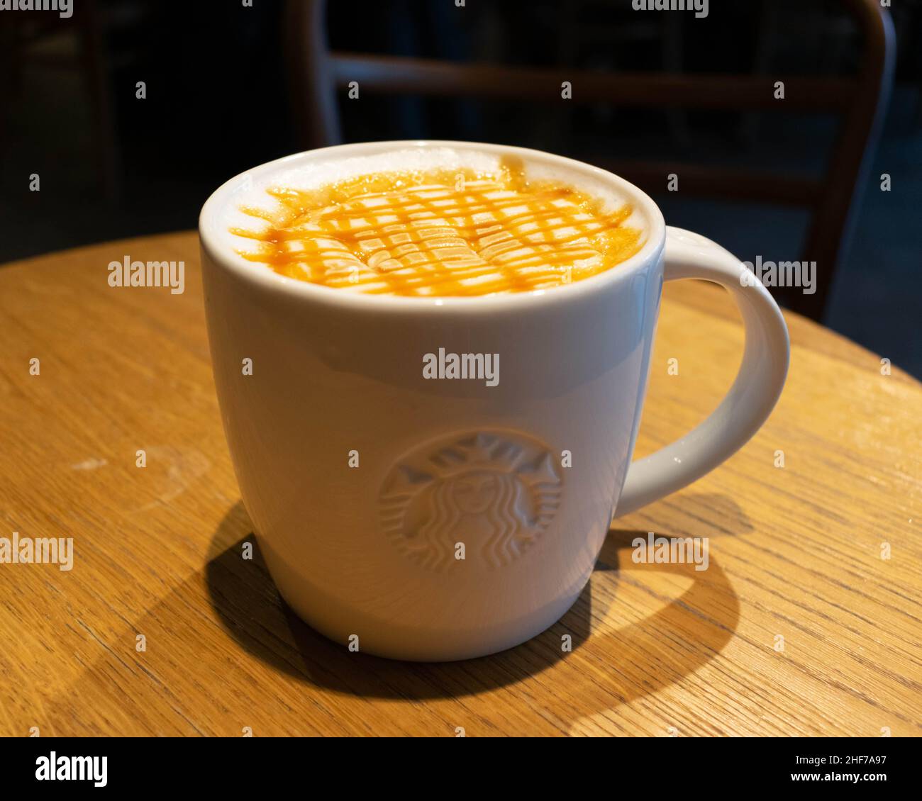 Starbucks Kaffee Caramel Macchiato Nahaufnahme auf einem Holztisch mit Schaum und Sauce Stockfoto