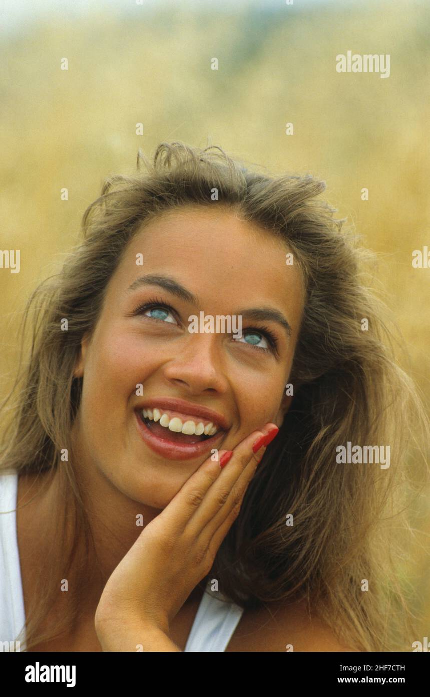 Attraktive braune Haare junge Frau Porträt suchen hohe Front Kamera Hintergrund Nahaufnahme natürliche glücklich lächelndes Gesicht Stockfoto