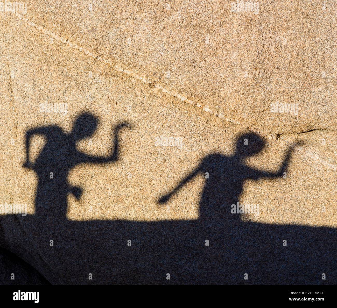 Kinder spielen mit Schatten auf einem Felsen im Juschua Tree Nationalpark Stockfoto