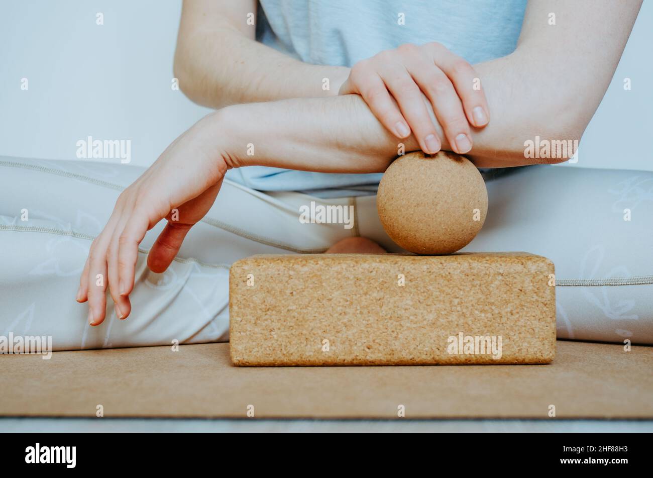 Unterarmmuskulatur myofasziale Freisetzung mit Massageball auf Korkblock. Konzept: Selbstpflege zu Hause, nachhaltige und umweltfreundliche Requisiten Stockfoto