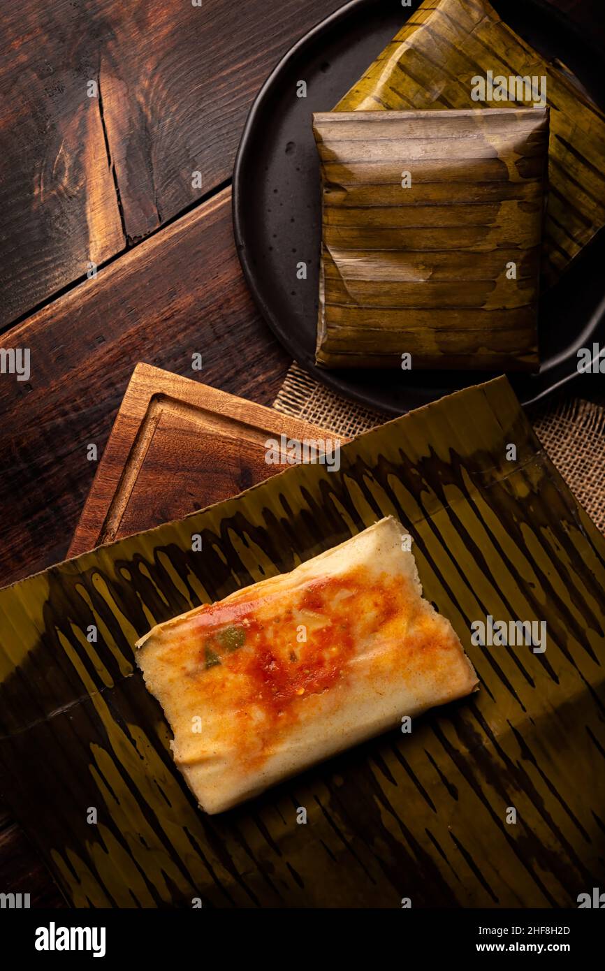 Prähispanische Gericht typisch für Mexiko und einige lateinamerikanische Länder. Maisteig in Bananenblätter gewickelt. Die Tamales werden gedämpft. Stockfoto