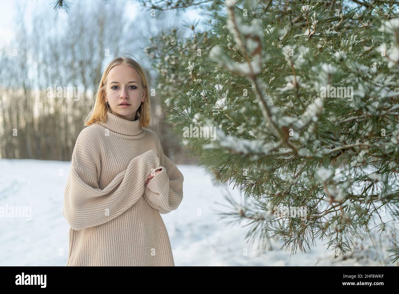 Portrait Mädchen Teenager blond Winter auf dem Hintergrund von schneebedeckten Bäumen. Stockfoto