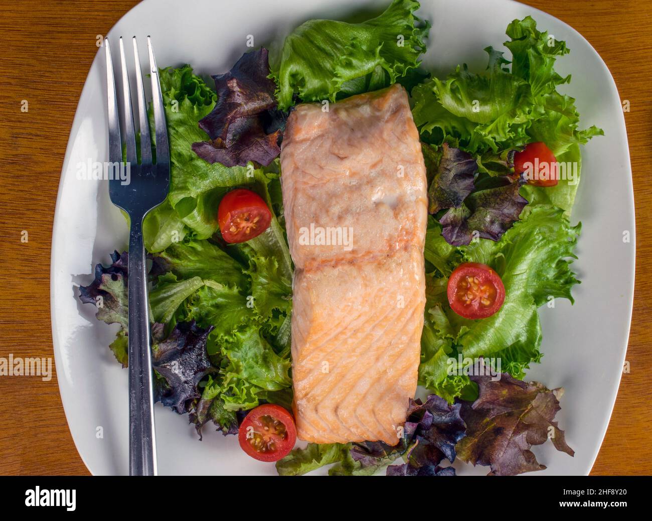 Gebackener Lachs mit gemischtem Gemüse und Tomaten Stockfoto