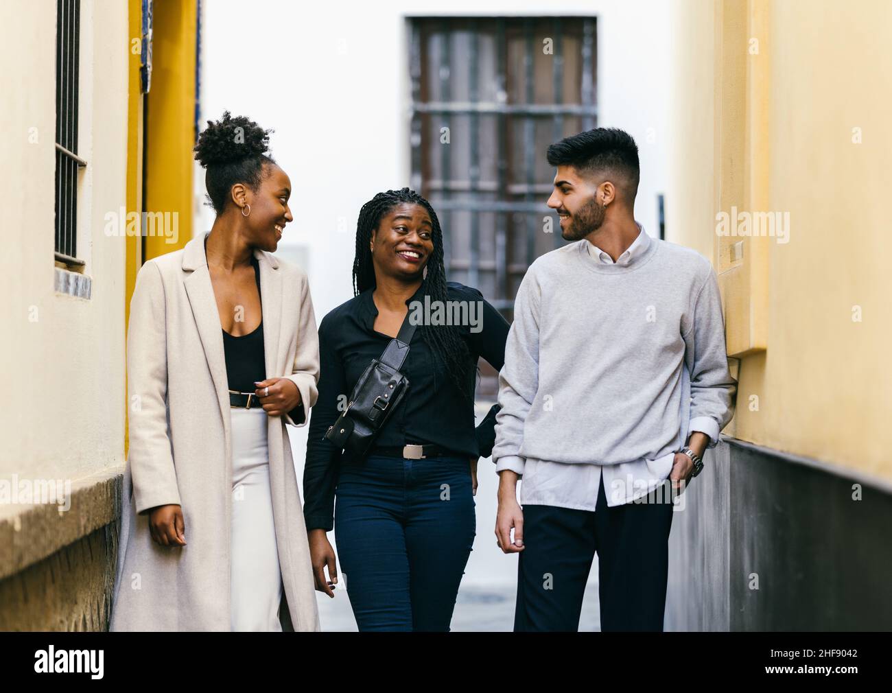 Drei multiethnische Menschen unterhalten sich auf der Straße lebhaft Stockfoto