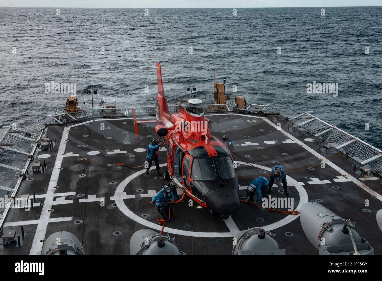 Mitglieder der Küstenwache an Bord des USCGC Stratton (WMSL 752) führen Verzurrungsoperationen mit einem MH-65E Dolphin-Hubschrauber im Pazifischen Ozean durch, 29. Dezember 2021. Die Crew von Stratton führte Flugoperationen durch, um die operativen Fähigkeiten aufrechtzuerhalten und die Bereitschaft zu erhöhen. (USA Foto der Küstenwache des U.S. Marine Corps Sgt. Sarah Stegall) Stockfoto