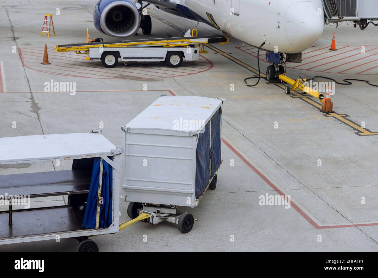 Güterwagen auf der Landebahn der Ladung zum Verkehrsflugzeug. Stockfoto