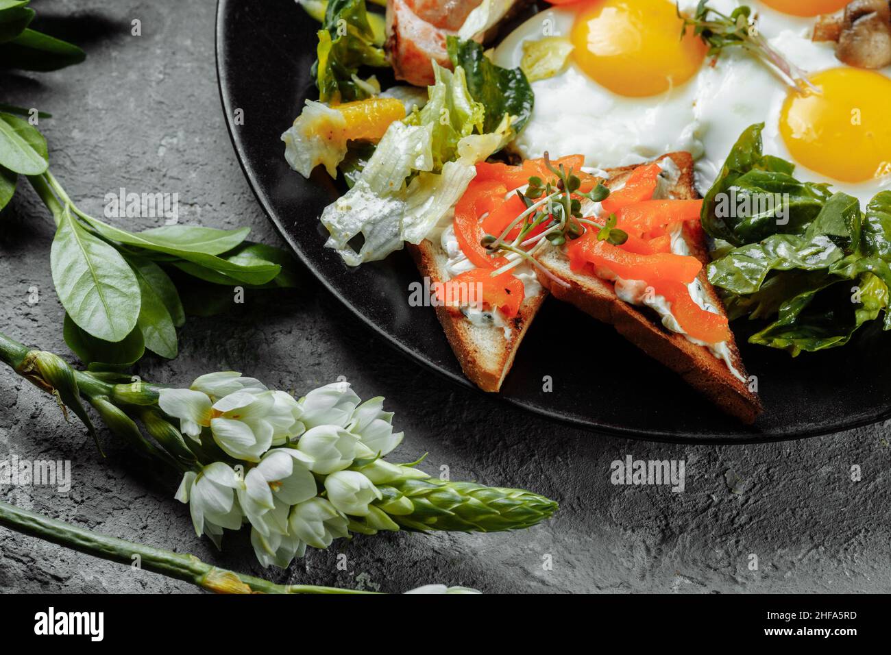 Komplettes englisches Frühstück mit Toastbrot, Hühnereier, Senfsauce, Champignons, Salatmischung, Käsecreme, Paprika Stockfoto