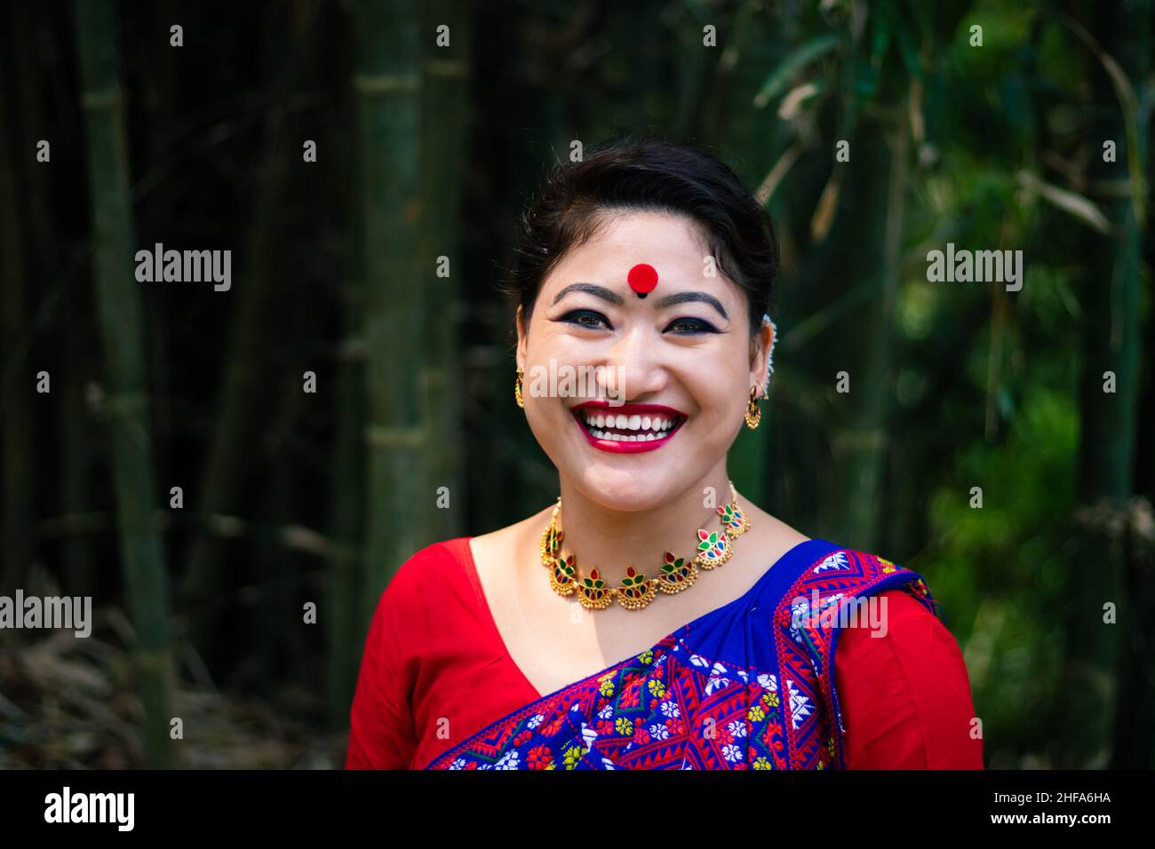 Mädchen lächelndes Gesicht isoliert in traditionellen tragen auf dem Festival mit verschwommenem Hintergrundbild gekleidet wird anlässlich der Bihu in assam indien aufgenommen. Stockfoto