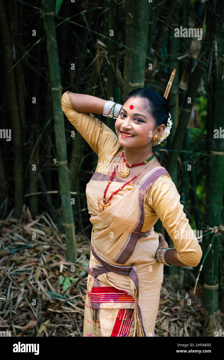 Mädchen in Tanzbewegung isoliert in traditionellen tragen auf dem Festival mit verschwommenem Hintergrund Bild gekleidet wird anlässlich der Bihu in assam indien aufgenommen. Stockfoto