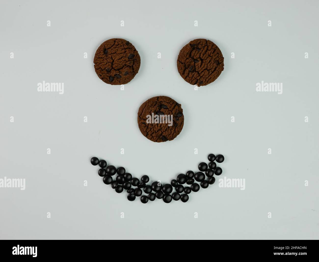 Kreatives Foto von Chocolate Chip Cookies, die ein lächelndes Gesicht bilden. Stockfoto