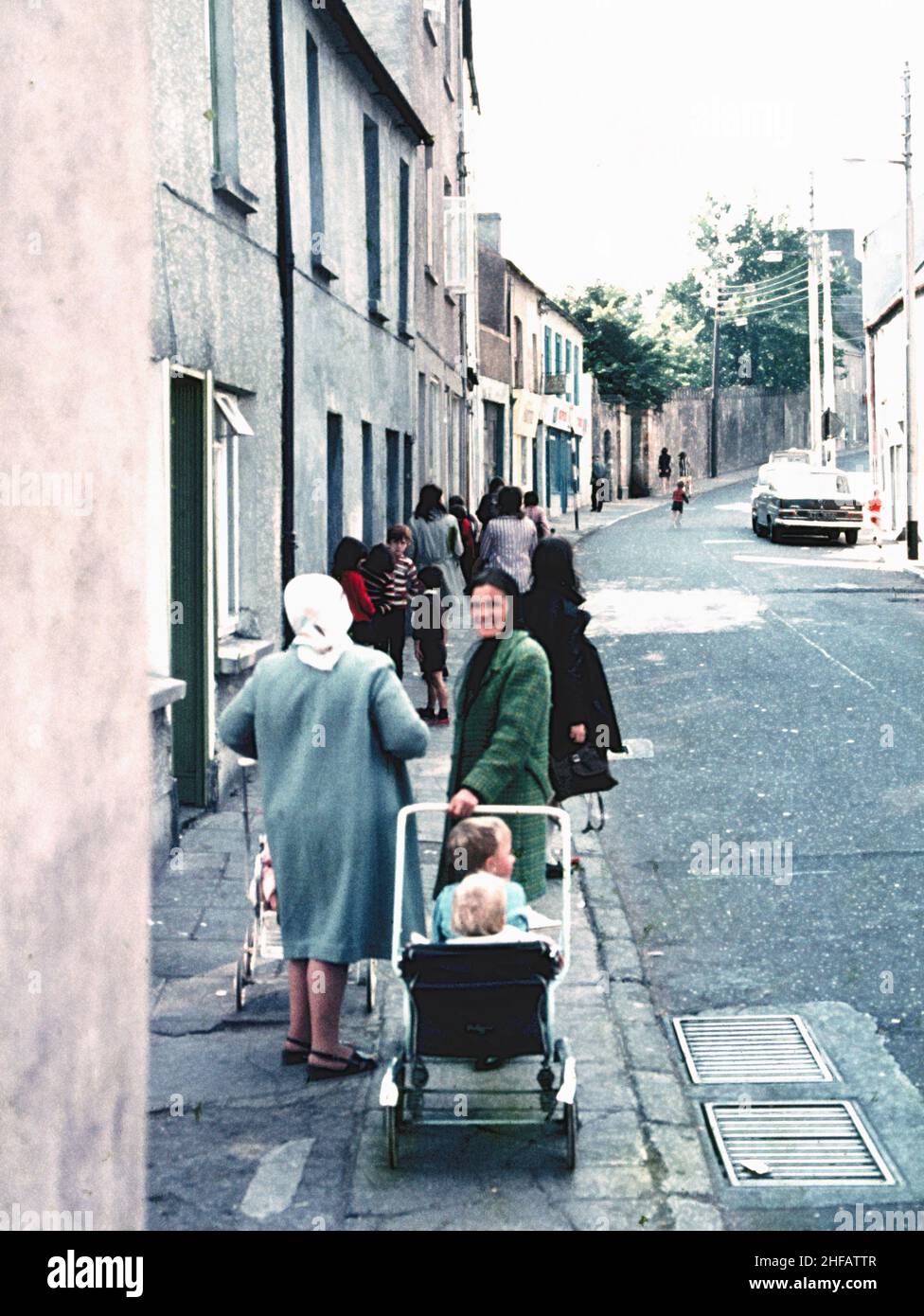 Eine Gruppe von Frauen mit Kindern, die Kinderwagen in 1970s Cork, Irland, schieben Stockfoto