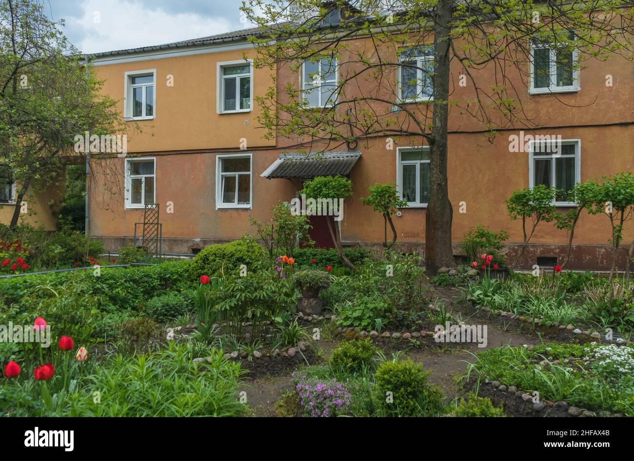 Schöner Garten vor dem 2-stöckigen Haus in Königsberg am glooomigen Frühlingstag Stockfoto