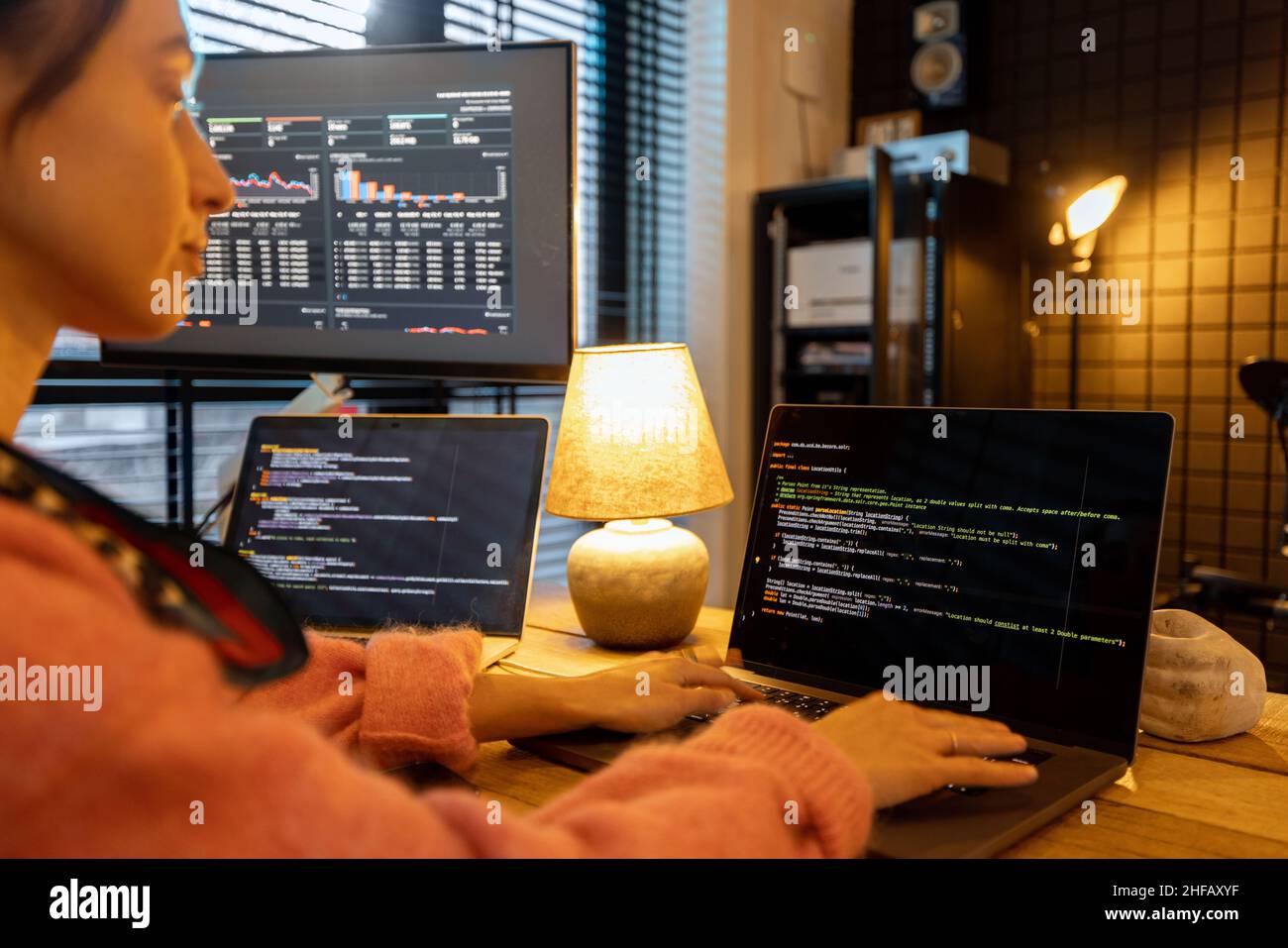 Weibliche Programmiererin, die Programmiercode am gemütlichen Arbeitsplatz zu Hause schreibt Stockfoto