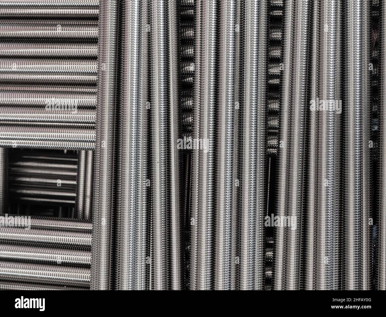 Übereinander gestapelte Gewindestangen aus Edelstahl. Stockfoto