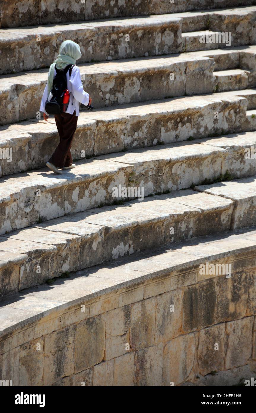 Ein individueller Tourist, der auf den Ständen von Jerash's griechisch-römisches nördliches Amphitheater, Jerash جرش, Jordanien, spaziert Stockfoto