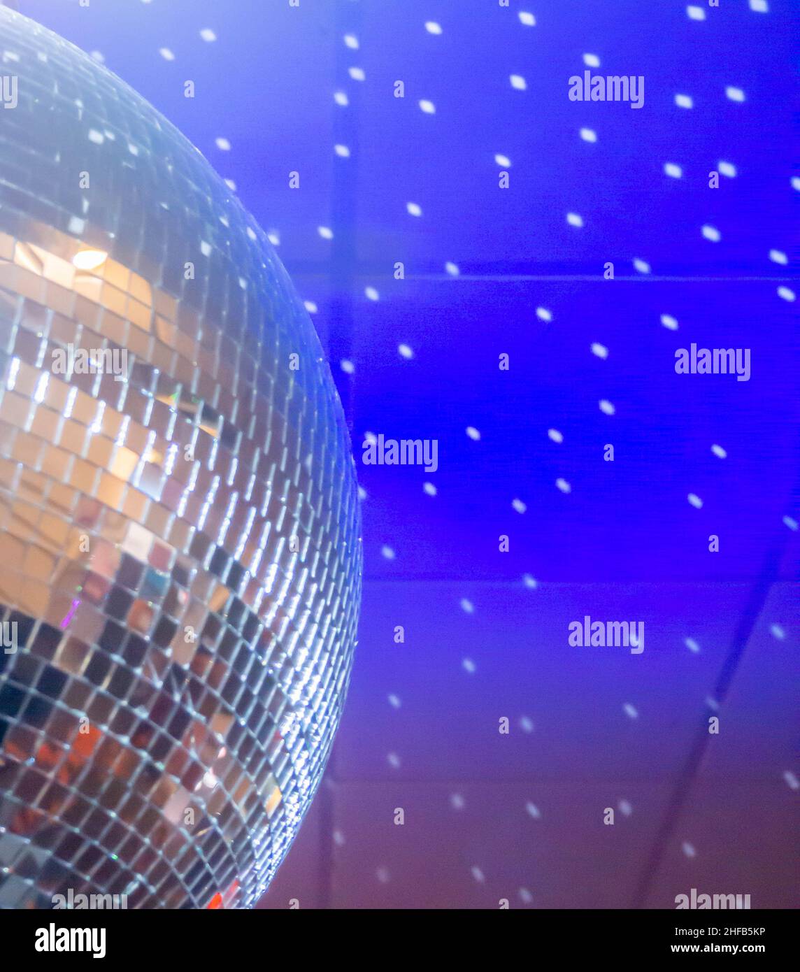 Giant Mirror Ball reflektiert Lichtpunkte an der blauen Decke Stockfoto
