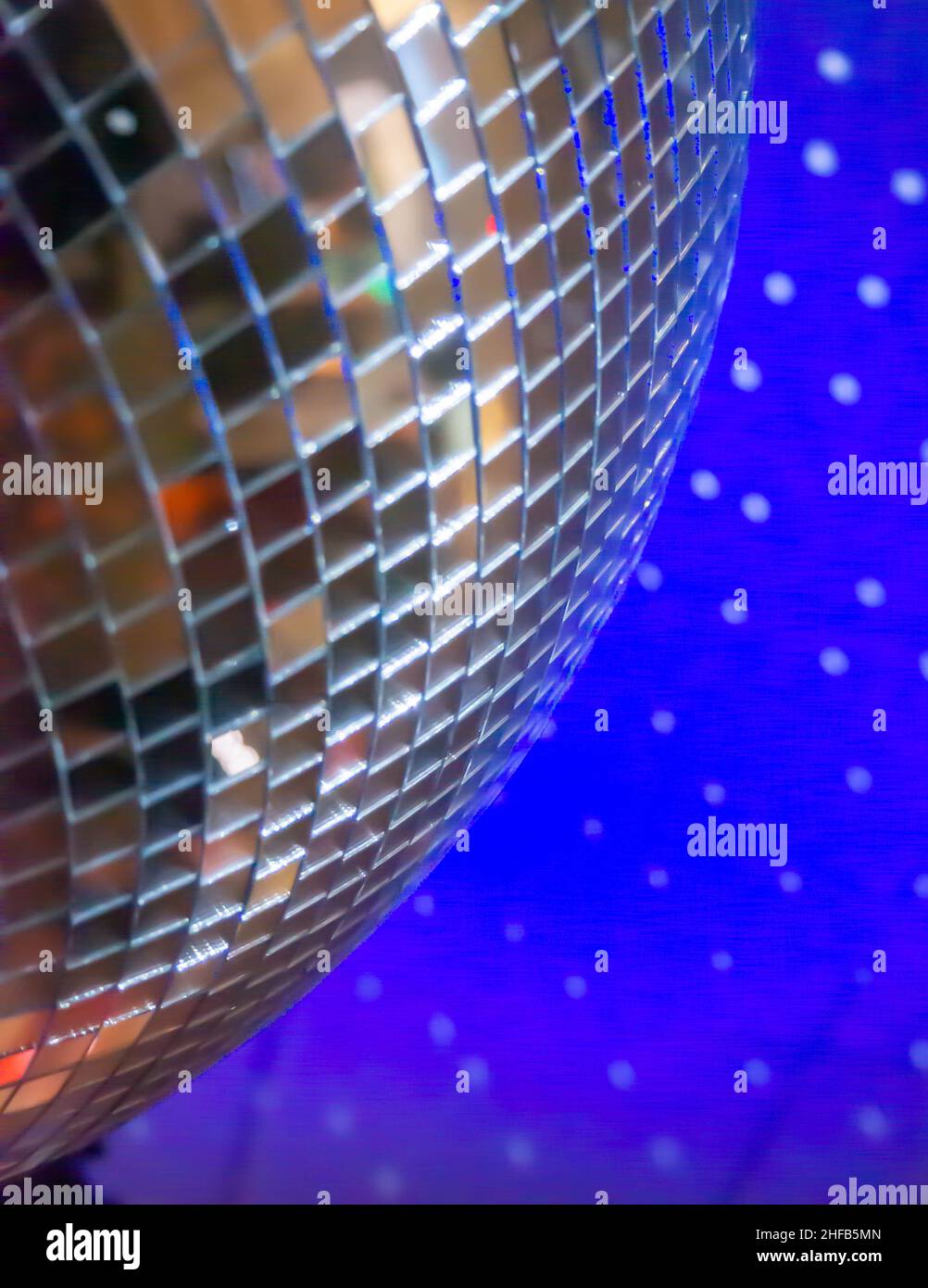 Giant Mirror Ball reflektiert Lichtpunkte an der blauen Decke Stockfoto