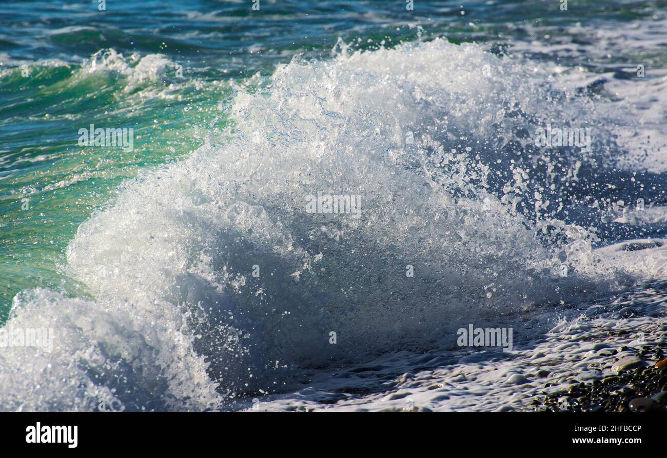 Blaue Welle bricht an einem Strand im Meer. Stockfoto