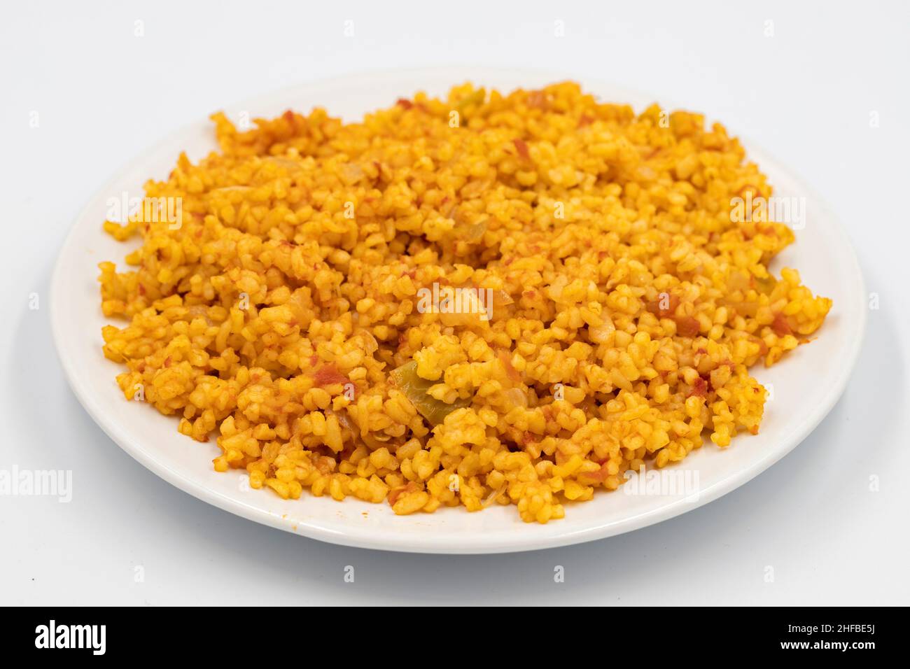 Bulgur Pilaf auf weißem Hintergrund. Nahaufnahme des türkischen Essens Bulgur Pilav in einer Keramikplatte Stockfoto