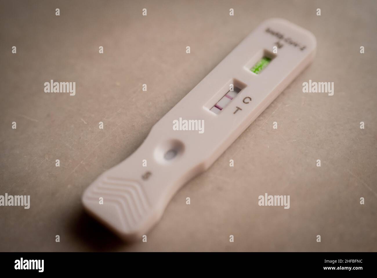 Die Abbildung zeigt einen schnellen SARS-CoV-2-Antigentest, der positiv ausfällt. Heute setzt Spanien die Preisobergrenze für Coronavirus-Antigen-Tests für €2,94 fest. Stockfoto