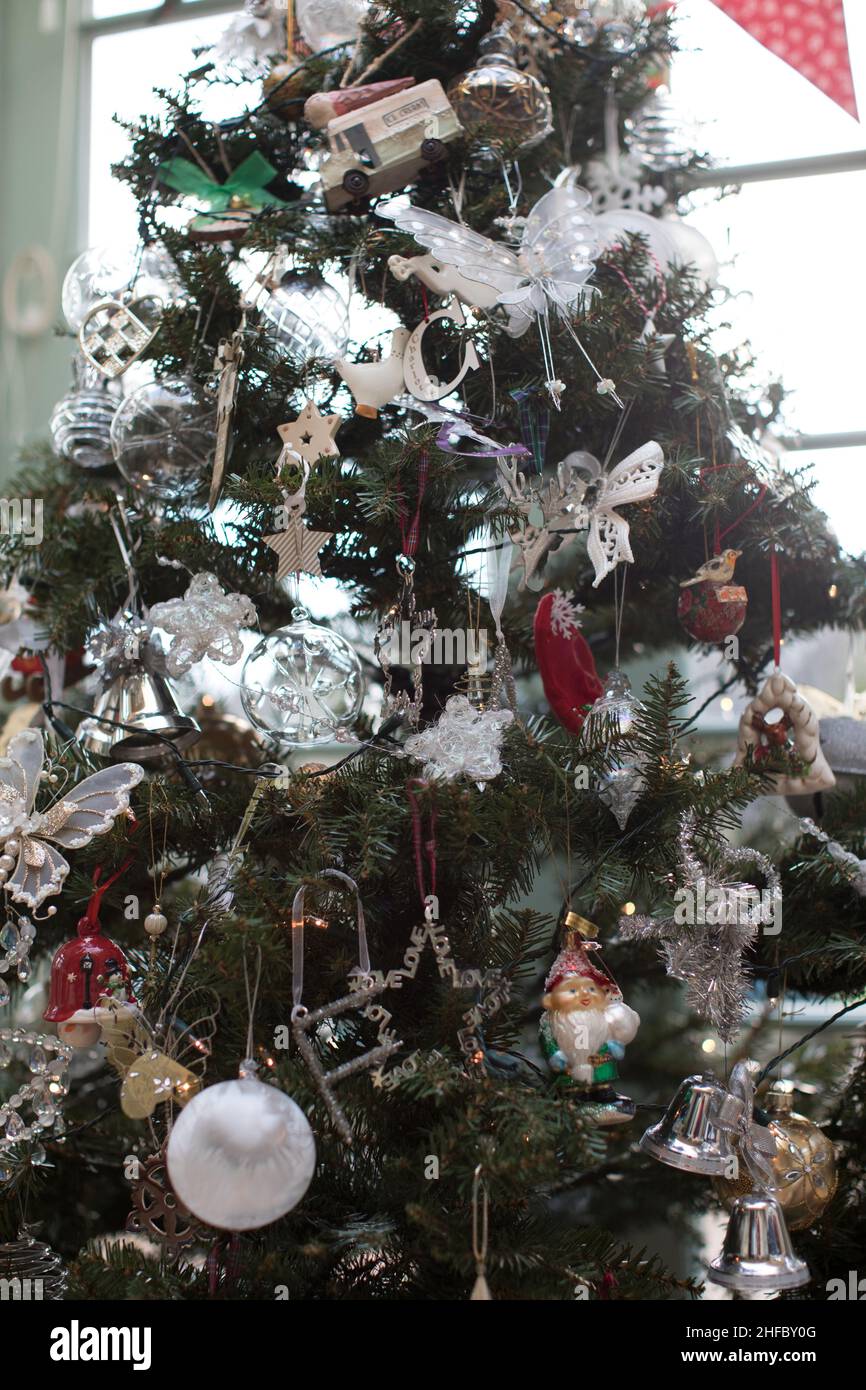 Künstlicher weihnachtsbaum mit weißen, silbernen und roten Verzierungen Stockfoto