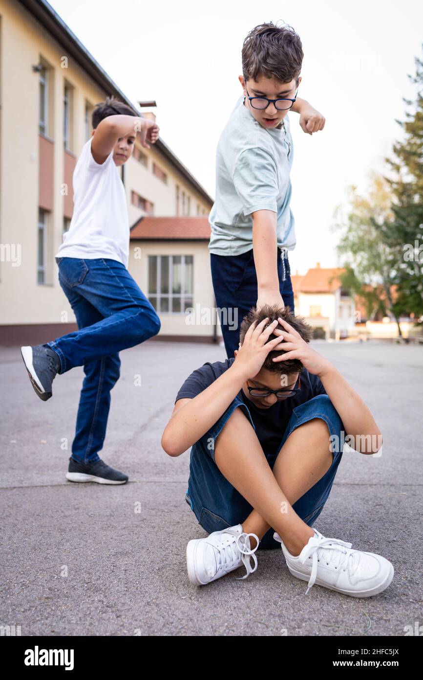 Ein Junge schikaniert seinen Schulkameraden. Missbräuchliches Verhalten von Kindern Stockfoto