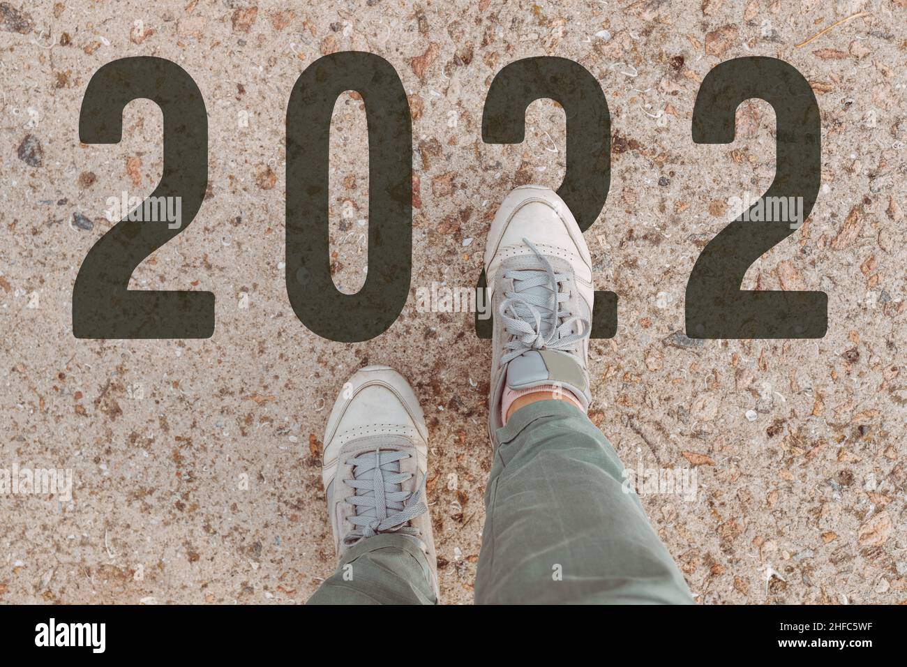 Nahaufnahme der weiblichen Füße in Sneakers am Start. Neubeginn des neuen Jahres 2023, Ziele und Pläne für das nächste Jahr Stockfoto