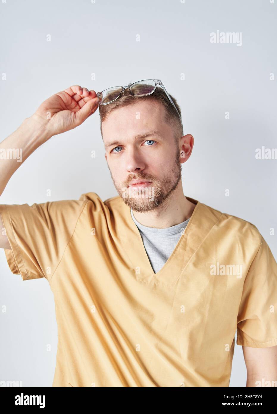 Nahaufnahme eines männlichen Arztes oder einer Krankenschwester mit seinen Armen, die eine Brille hochheben. Professioneller kaukasischer Arzt im Krankenhaus. Medical Healthcare Business und Arzt Service-Konzept. Hochwertige Fotos Stockfoto