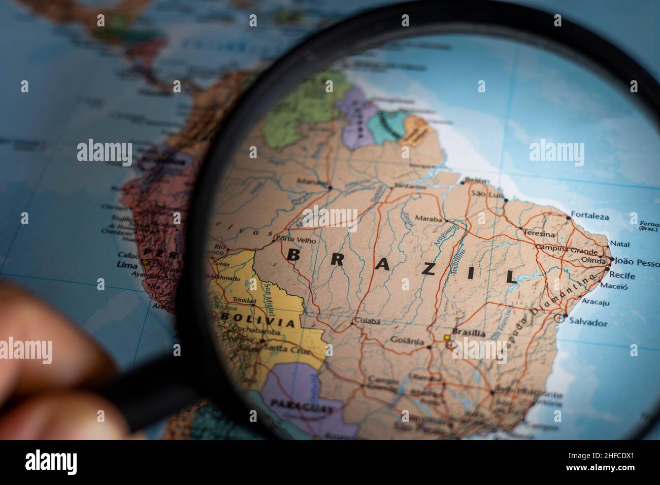 Brasilien auf einer Weltkarte durch Vergrößerungsglas. Planung von Reisezielen in Brasilien festgeklemmt Stockfoto