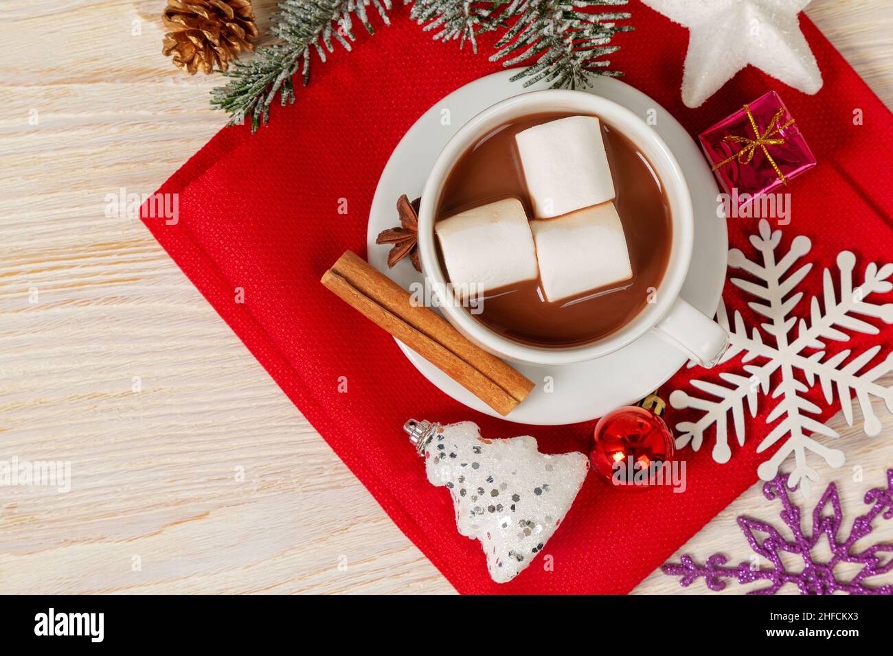 Heiße Schokolade oder Kakao-Getränk mit Moorsalbe in einer weißen Tasse und Zimt auf einem hölzernen Hintergrund. Weihnachten und Neujahr traditionelle Küche. Draufsicht Stockfoto