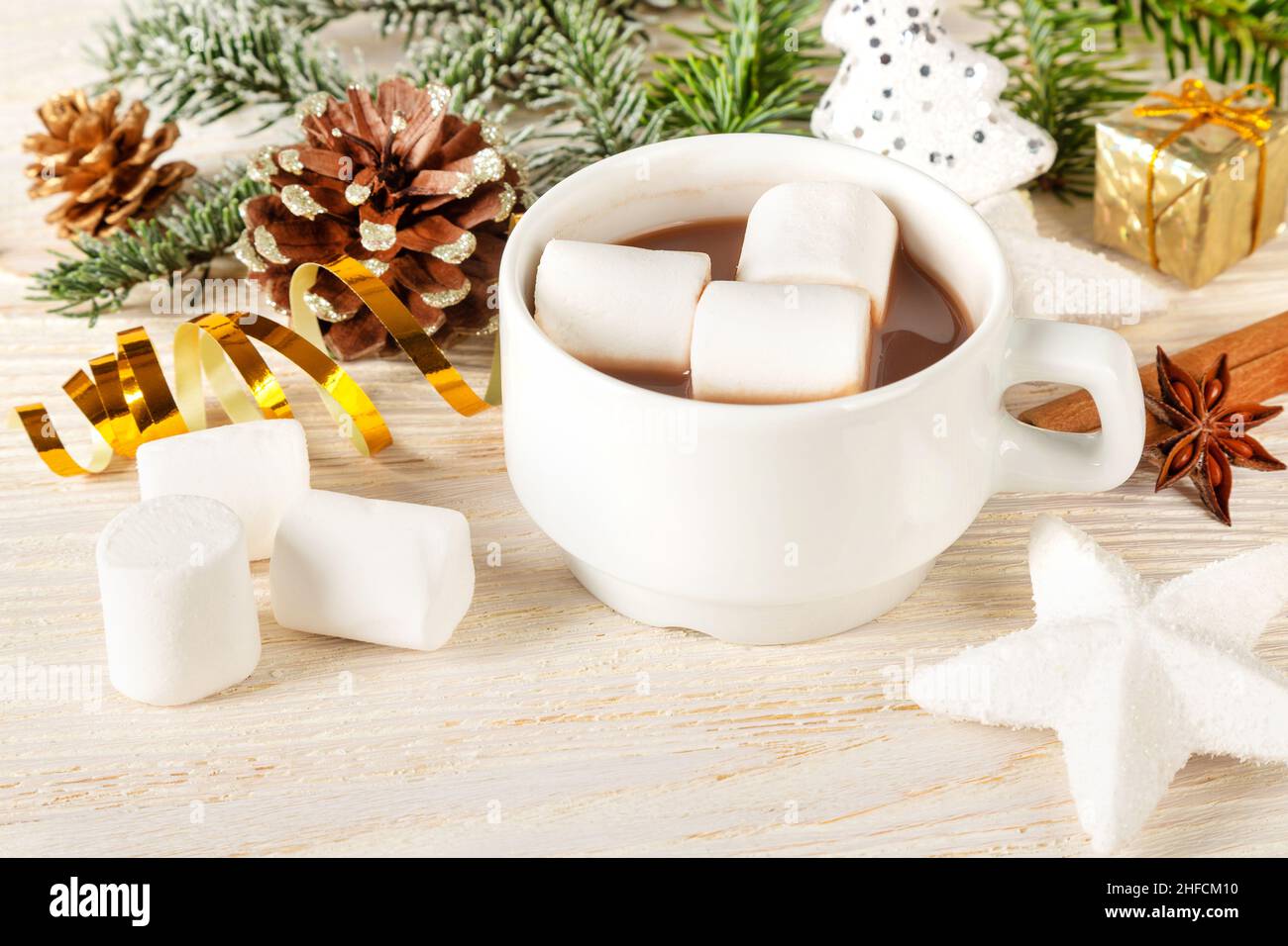 Heiße Schokolade oder Kakao-Getränk mit Moormarmelin in einer weißen Tasse und Dekorationen auf einem Holzhintergrund. Weihnachten und Neujahr traditionelle Küche. Stockfoto