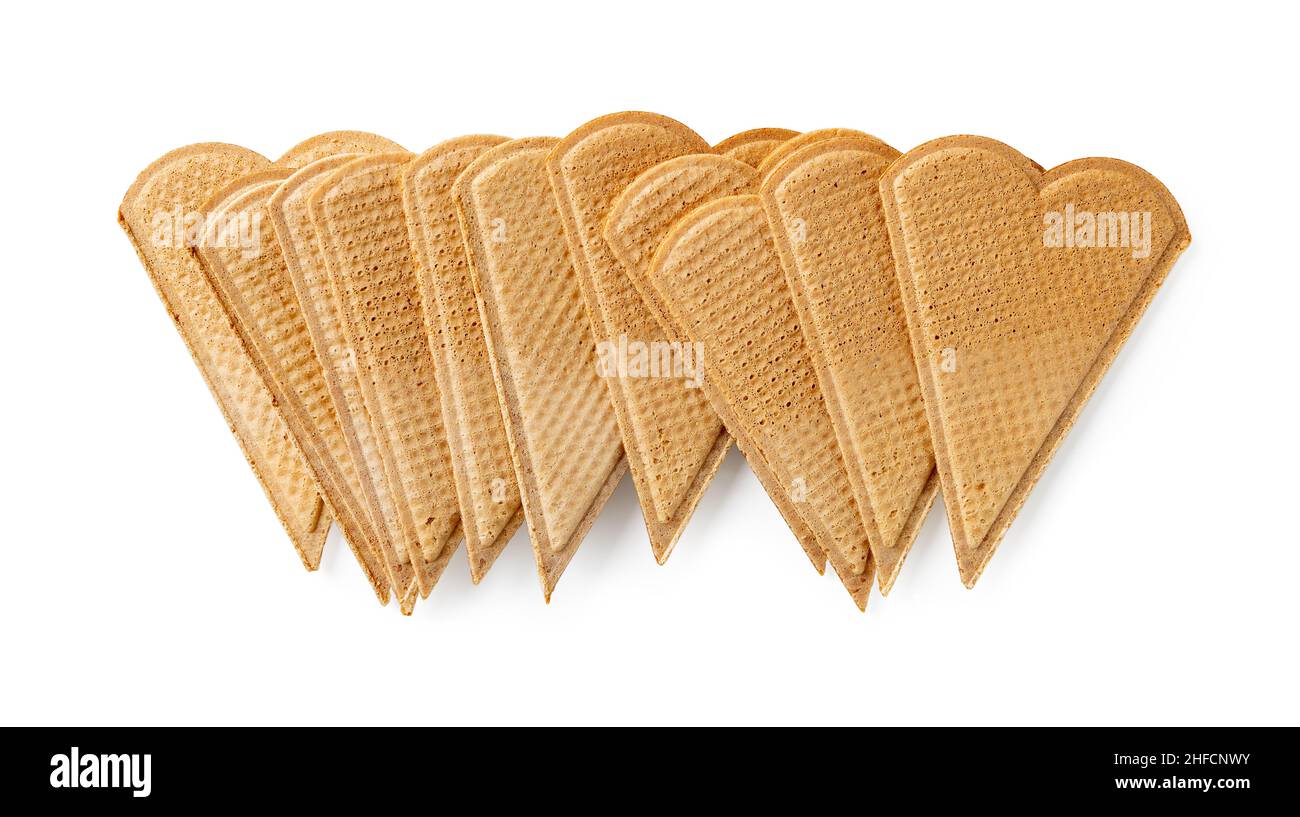 Haufen süßer herzförmiger Waffeln zur Eisdekoration isoliert auf weißem Hintergrund. Dünne flache Waffelplätzchen für die Dessert-Garnierung Makro. Stockfoto