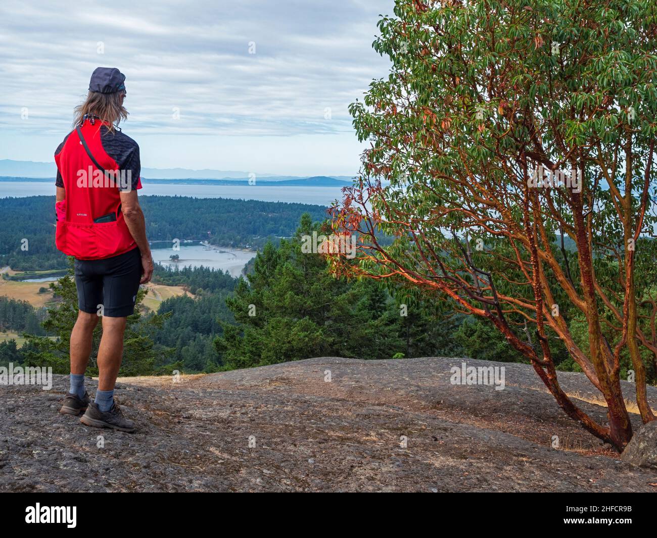 WA21134-00...WASHINGTON - Radsportler vom Gipfel des Young Hill aus über die Garrison Bay mit der Haro Strait, Vancouver Island und Olympic Mtns. Stockfoto