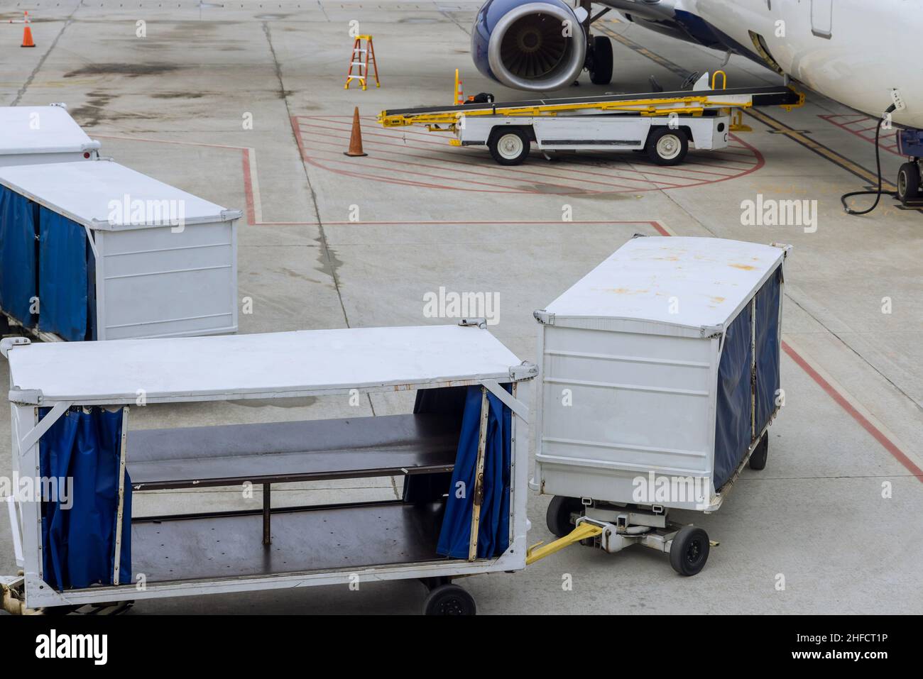 Flughafenbahn mit Ladetransport auf dem Flugzeug warten Stockfoto