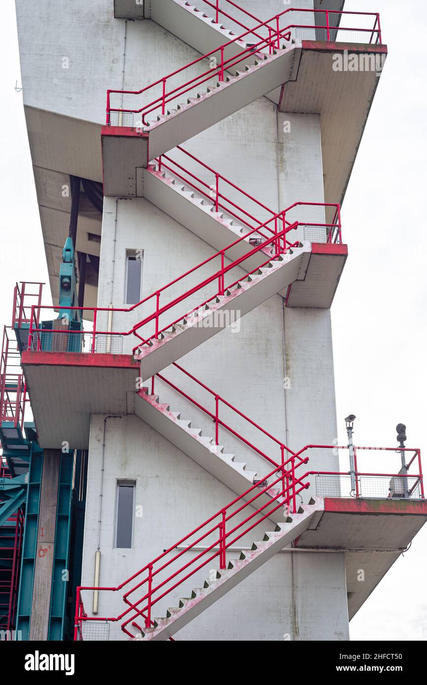 Rot lackierte Treppe auf einem Industriebetonturm Stockfoto