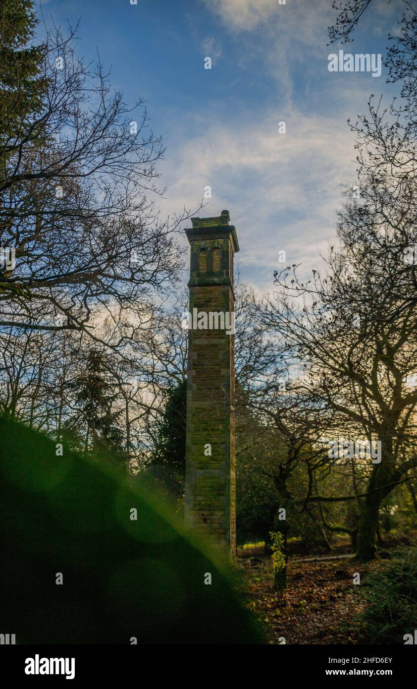 Steinturm in den Gärten von Denzell (möglicherweise ein Wasserturm), umgeben von den ausgedehnten Wäldern des Geländes. Stockfoto