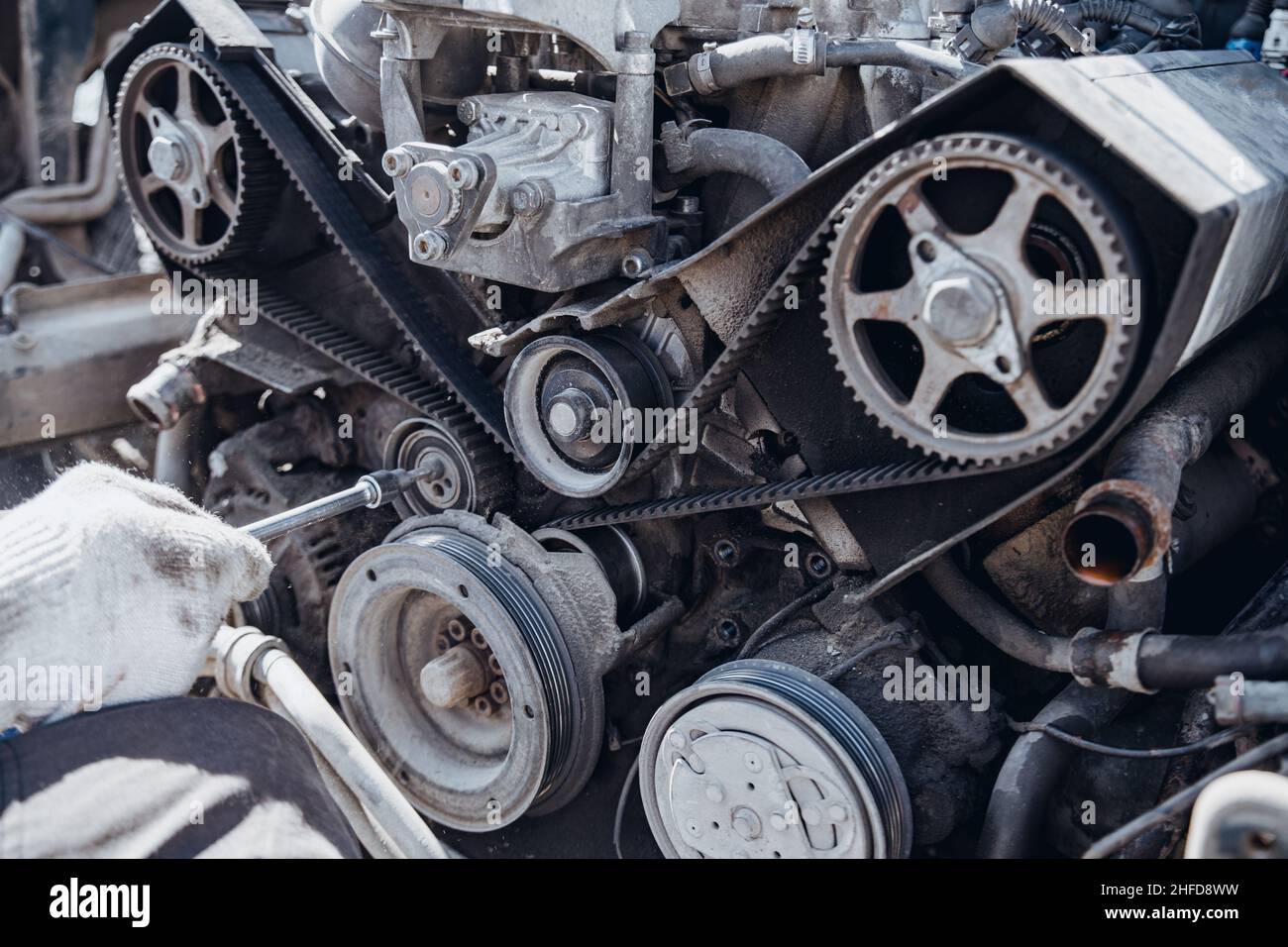 Der Automotor wird von der Seite des Riemens und der Steuerrollen in geringer Schärfentiefe demontiert Stockfoto