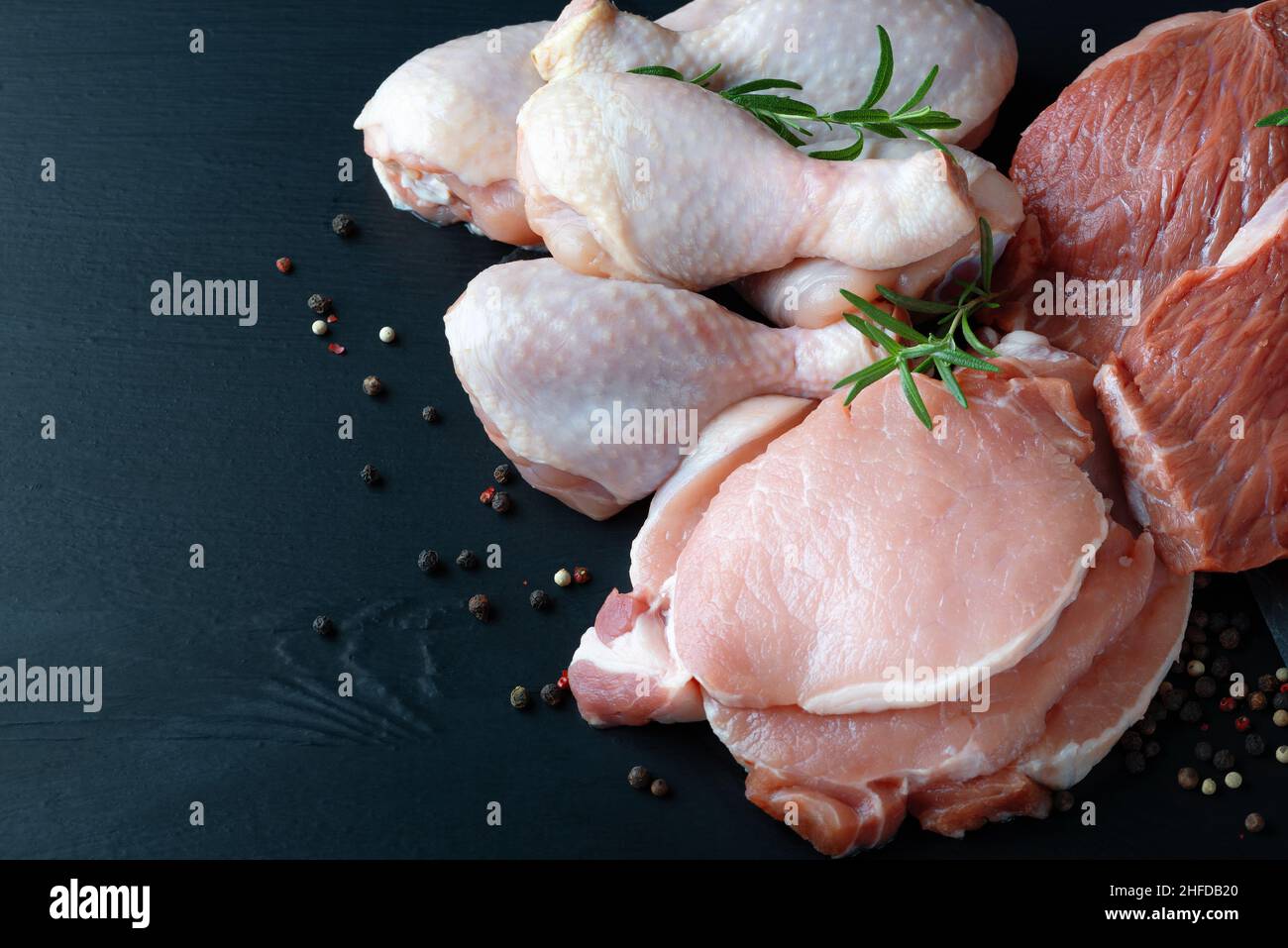 Verschiedene Arten von rohem Fleisch auf einem schwarzen Backgroun Stockfoto