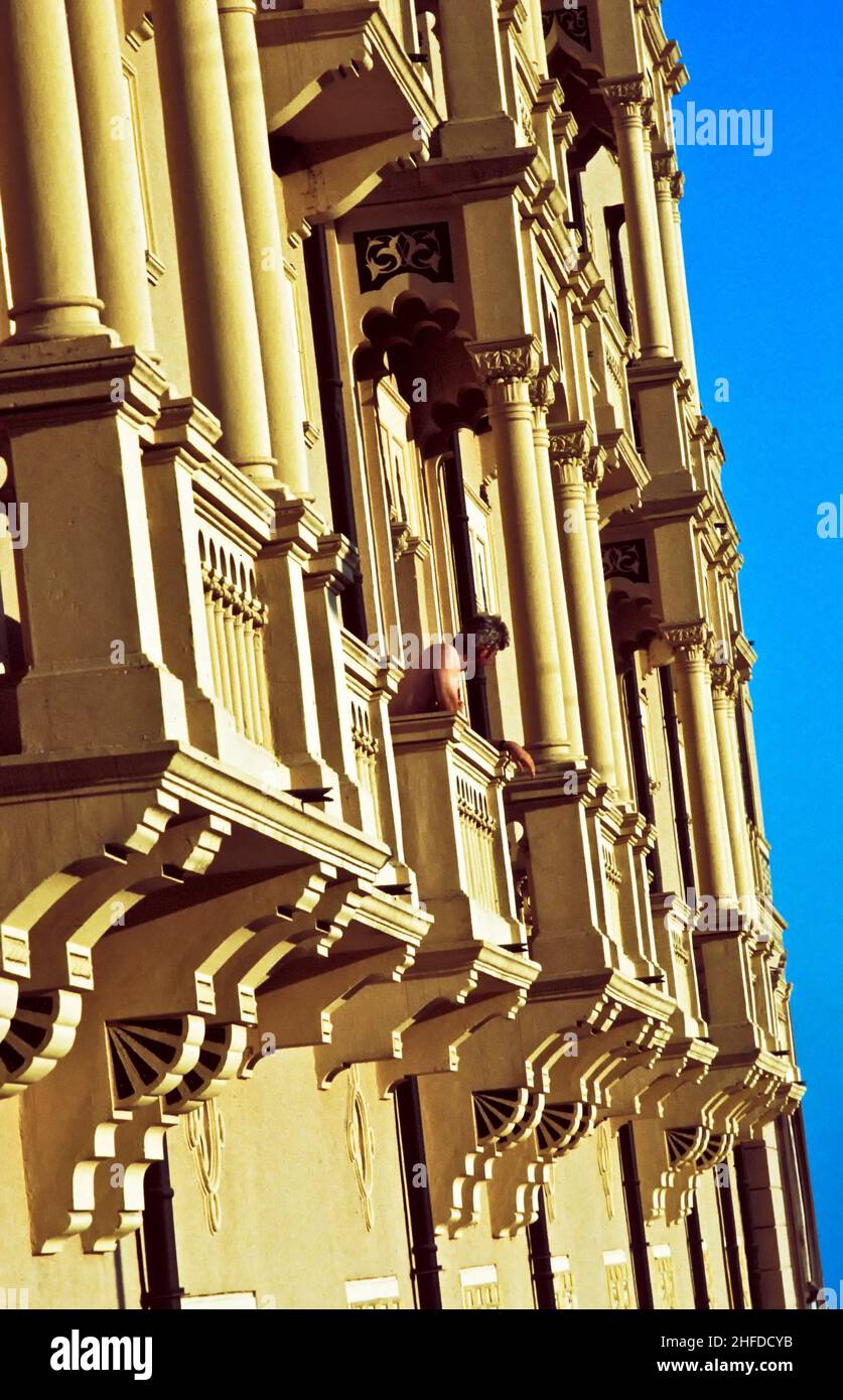 Mann blickte vom Balkon aus auf ein altes klassisches Hotel Stockfoto