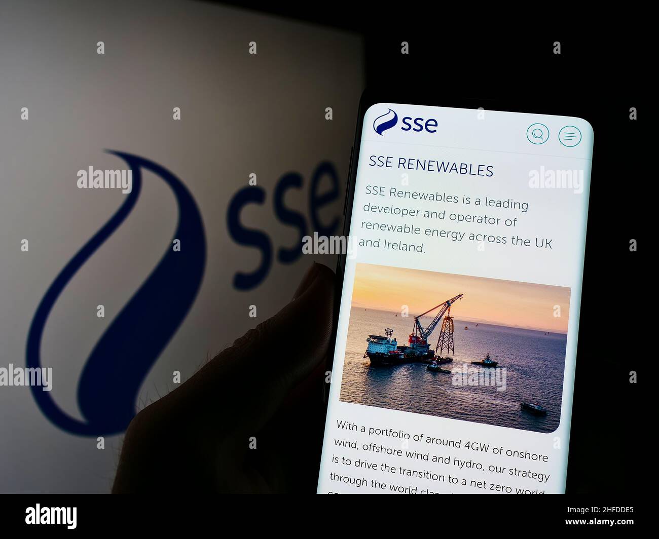 Person, die Mobiltelefon mit der Webseite des britischen Energieunternehmens SSE plc auf dem Bildschirm vor dem Unternehmenslogo hält. Konzentrieren Sie sich auf die Mitte des Telefondisplays. Stockfoto