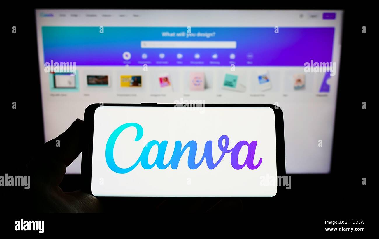 Person, die das Smartphone mit dem Logo des australischen Grafikdesignunternehmens Canva Pty Ltd auf dem Bildschirm vor der Website hält. Konzentrieren Sie sich auf die Telefonanzeige. Stockfoto