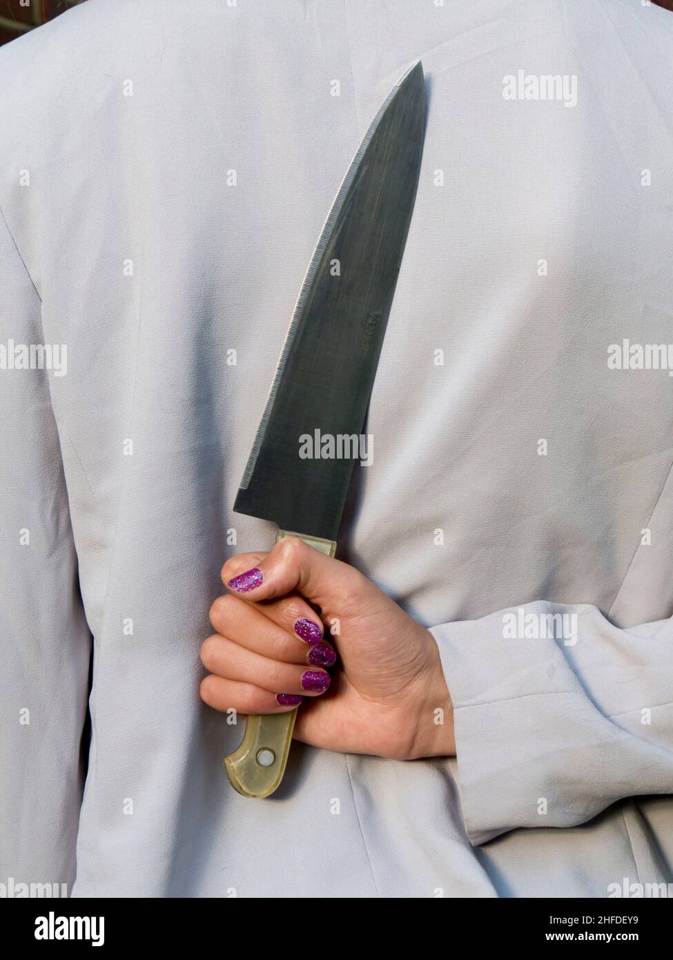 Mädchen Messer hinter dem Rücken Stockfoto