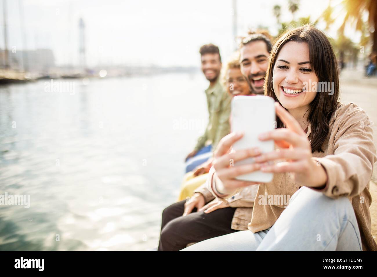 Multiethnische Gruppe von besten Freunden, die mit dem Smartphone vertikale Selfies machen Stockfoto