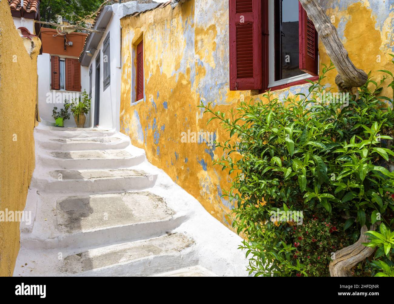 Straße im Plaka-Viertel, Athen, Griechenland, Europa. Gemütliche Gassen mit alten Häusern sind Touristenattraktion von Athen. Malerische schmale Gasse mit Stufen und Plan Stockfoto