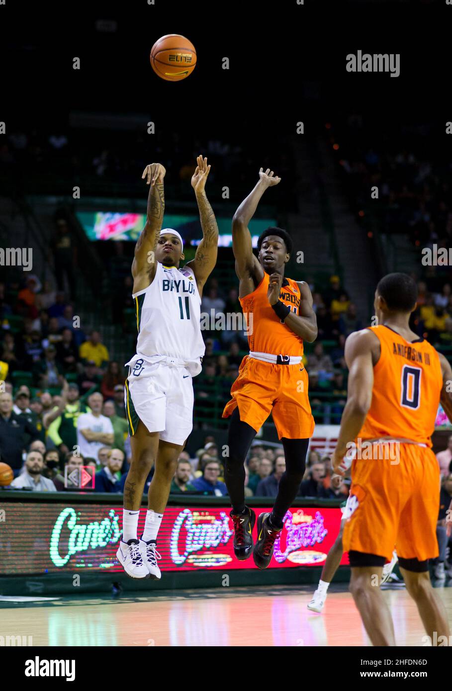 Waco, Texas, USA. 15th Januar 2022. Baylor Bears Wache James Akinjo (11) schießt den Ball gegen den Oklahoma State Cowboys Wache Bryce Williams (14) während der 2nd Halbzeit des NCAA Football Spiels zwischen den Texas Tech Red Raiders und Baylor Bears im Ferrell Center in Waco, Texas. Matthew Lynch/CSM/Alamy Live News Stockfoto