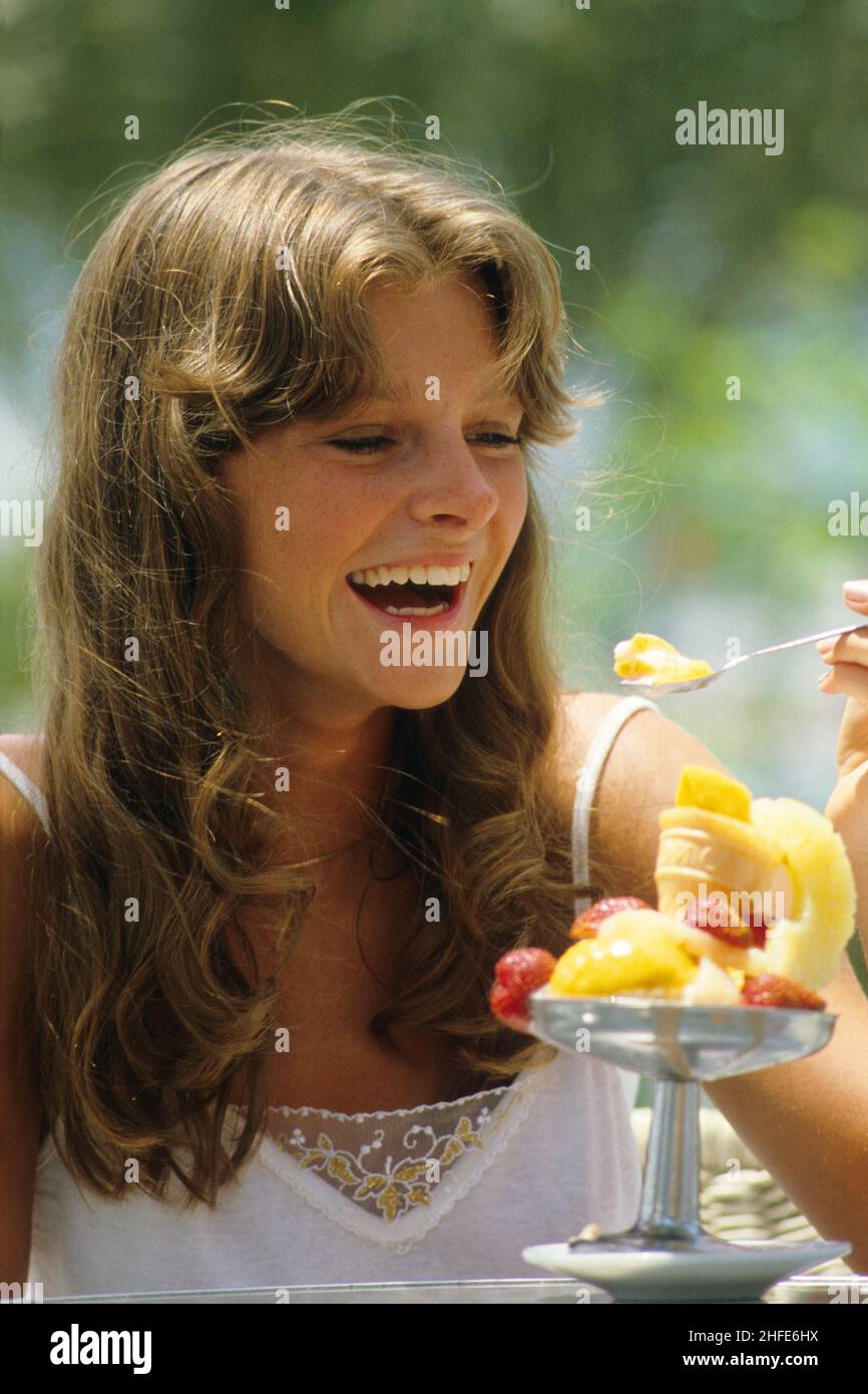 Lächelnd und glücklich blonde Haare junge Frau Porträt suchen einen riesigen Eisbecher lustig aussehen Stockfoto